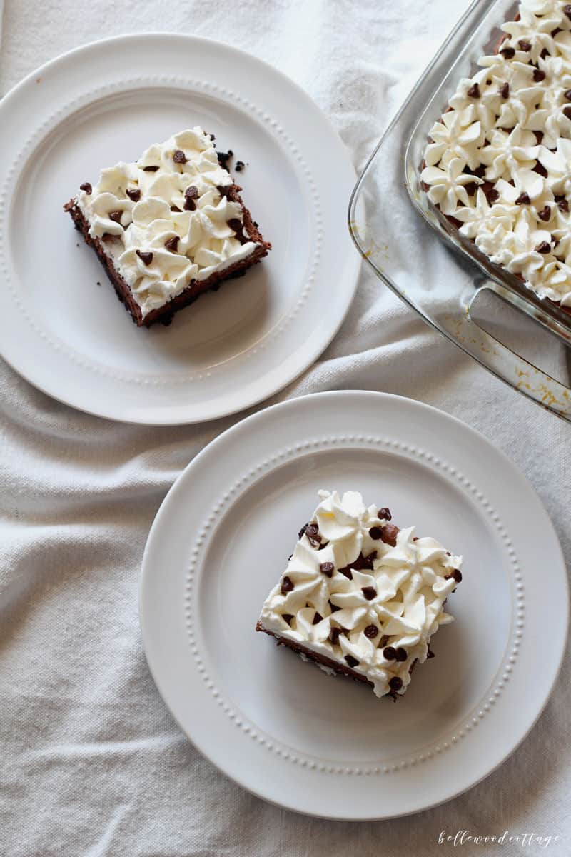 Square slices of chocolate pie topped with piped whipped cream and chocolate chips.