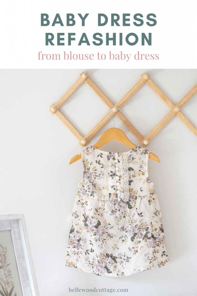 A baby dress sewn from an old blouse on a wooden hanger.