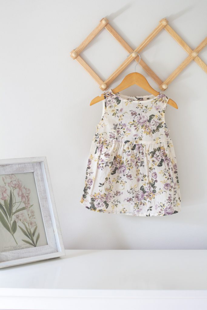 A baby dress refashion -- hanging on a wooden hanger.