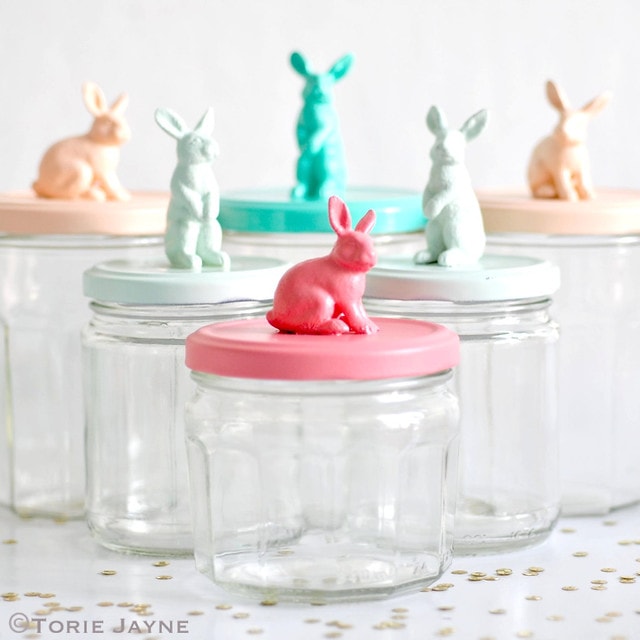Small jars with spray-painted bunny figurines on top.
