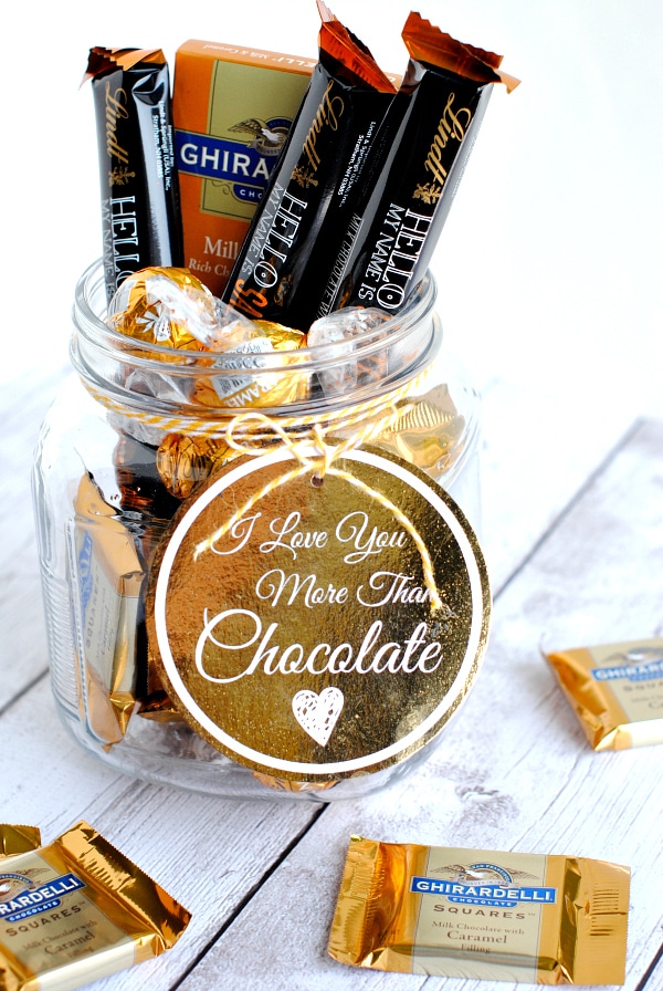 A mason jar filled with chocolate and a gift tag reading, "I love you more than chocolate".