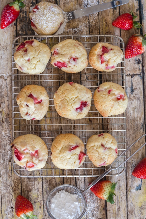Strawberry Cookies on a cooling rack surrounded by fresh strawberries.