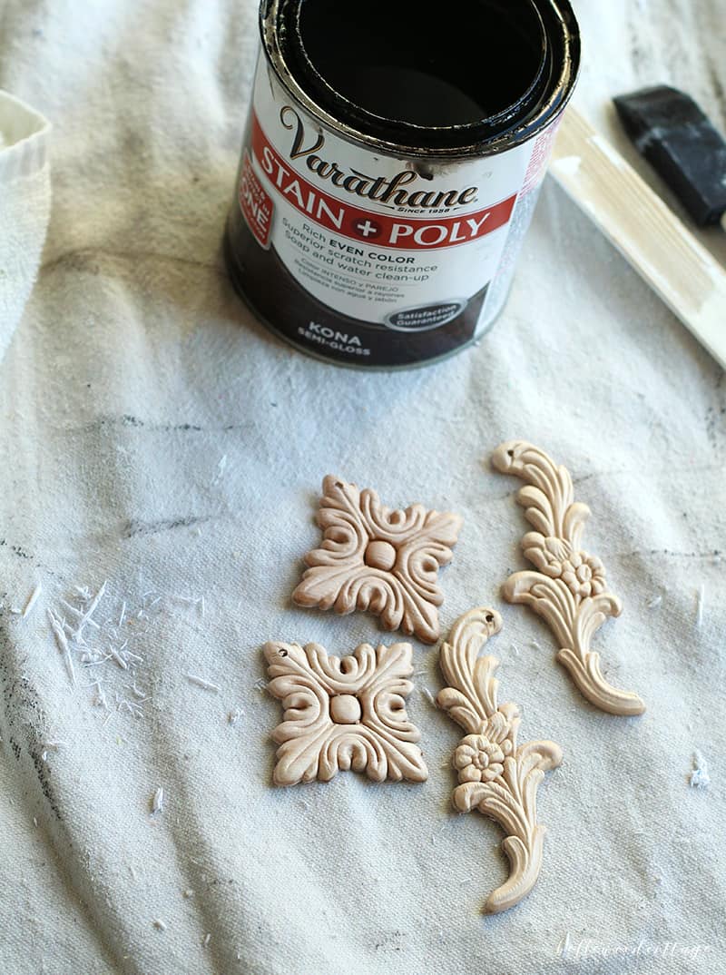 Wooden appliqués with a wood stain nearby.