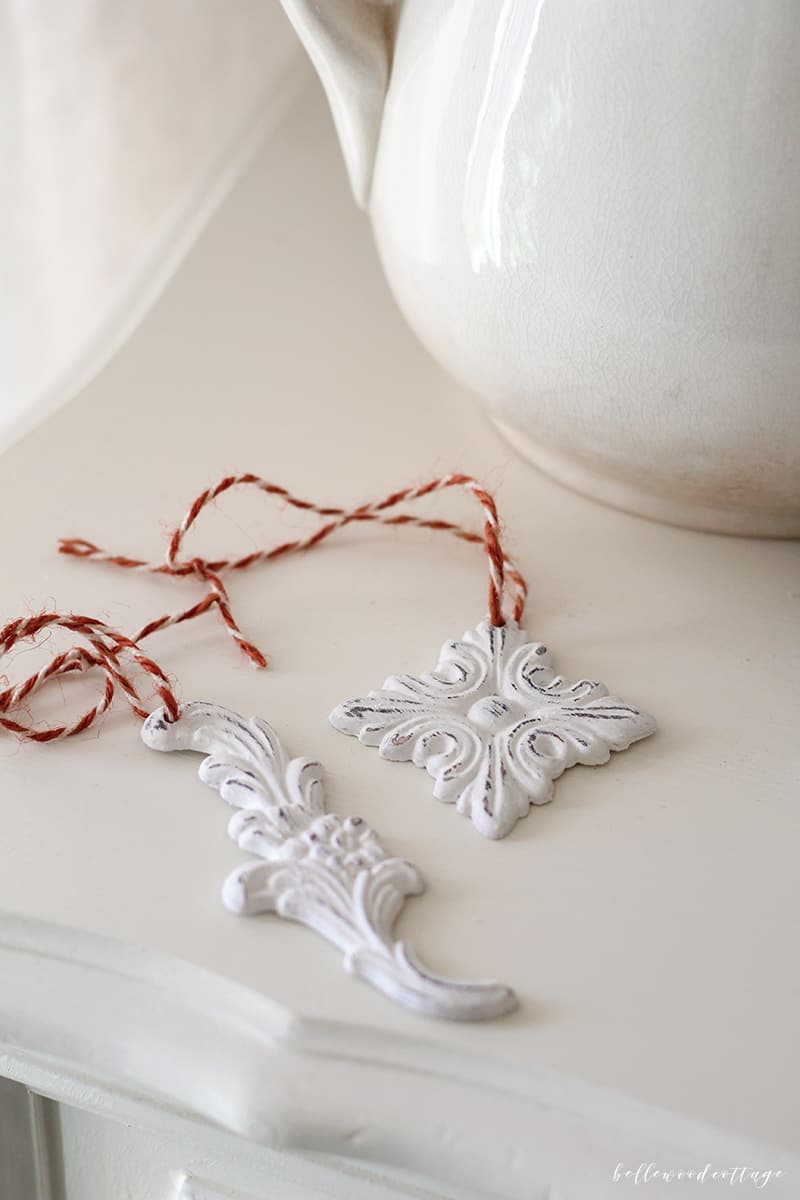 DIY handmade farmhouse style painted Christmas tree ornaments on a white dresser.