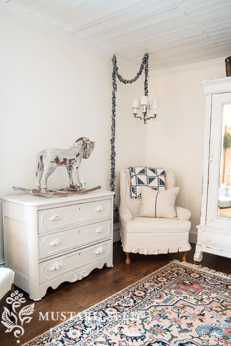 A living room with wingback chair slipcovered with bleached drop cloths.