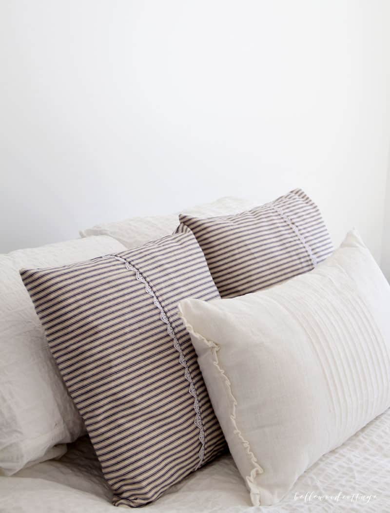 Learn how I made these farmhouse inspired ticking pillow covers over at Bellewood Cottage blog! They are so simple, easy, and inexpensive (total win). Add authentic farmhouse style to YOUR home with this quick project to make your own ticking pillow covers.