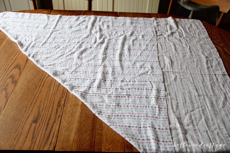 Muslin cotton gauze fabric arranged on a table ready to cut into a baby swaddle blanket.