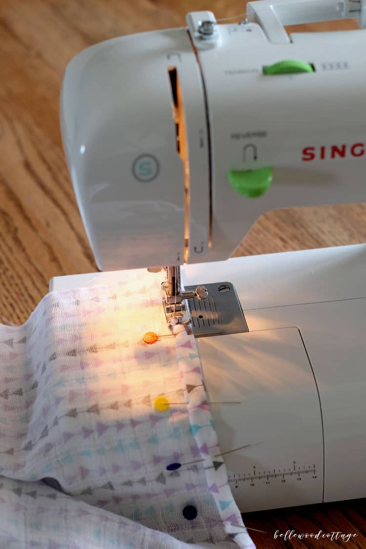 Sewing machine hemming a double gauze swaddle blanket.