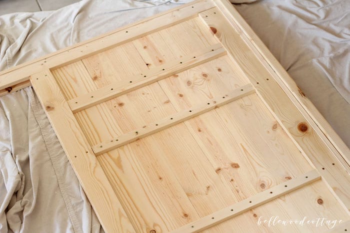 Learn how to create your own DIY rustic headboard with simple (and inexpensive!) pine boards and milk paint. Perfect for a farmhouse style home!