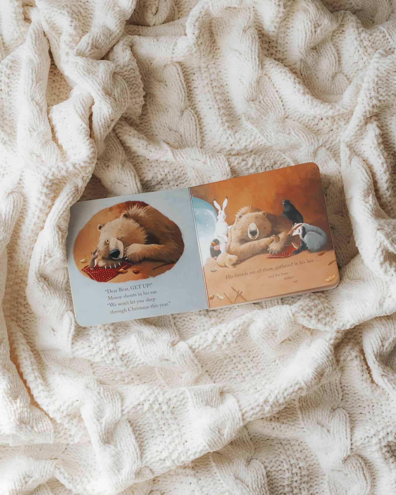 A toddler's board book on a cream-colored blanket.