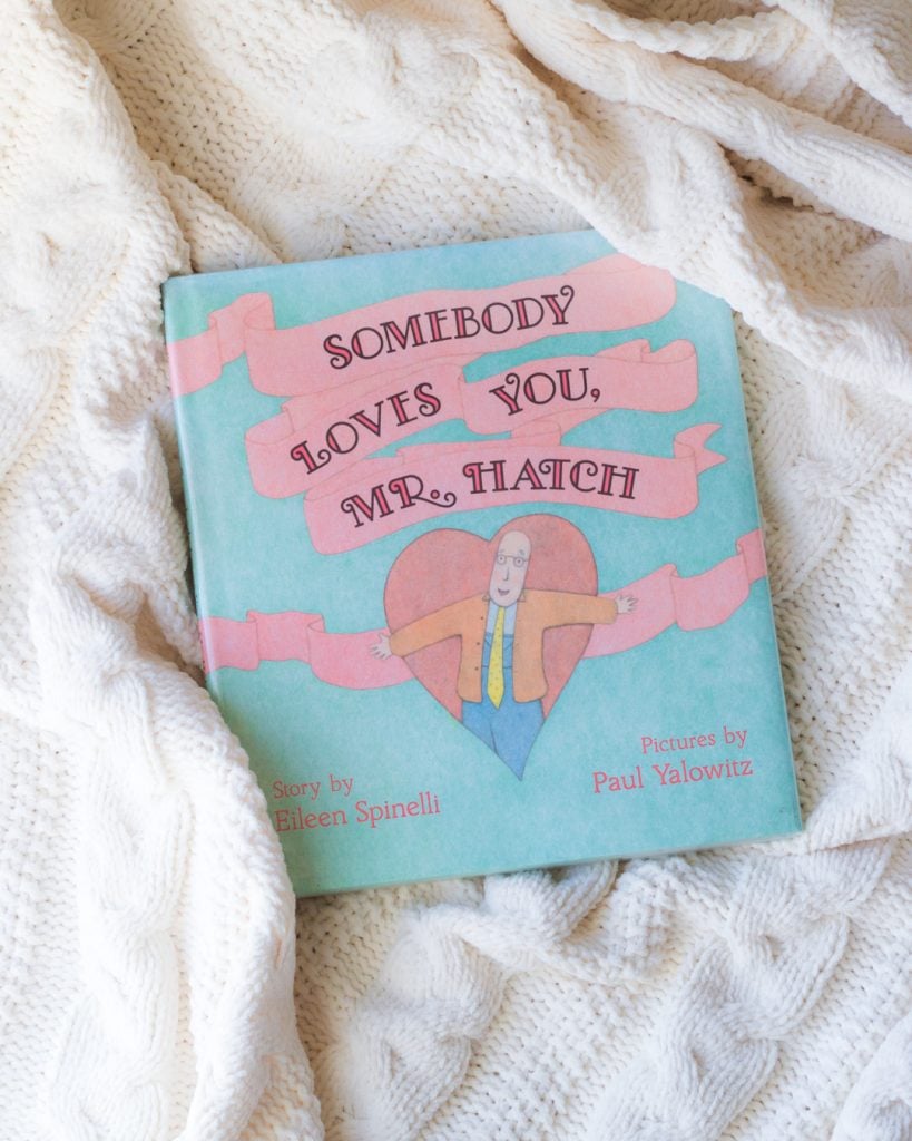 A photo of the picture book, Somebody Loves You, Mr. Hatch, on a wooden surface.