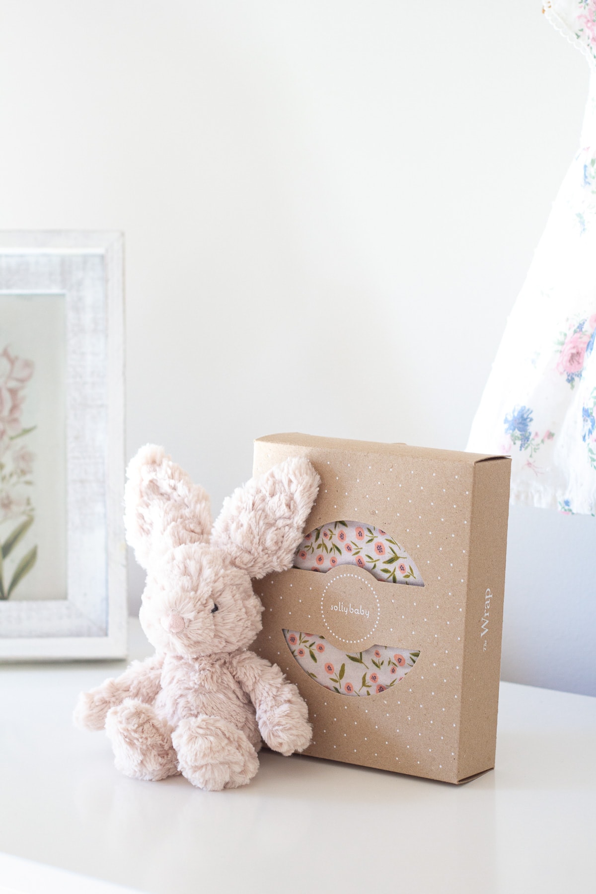 A floral print Solly Baby Wrap photographed on a white dresser for this Solly Baby Wrap Review.