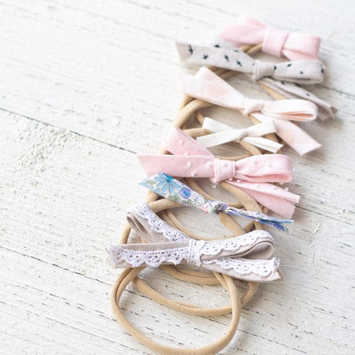 Seven bias tape hair bows on a wooden surface.