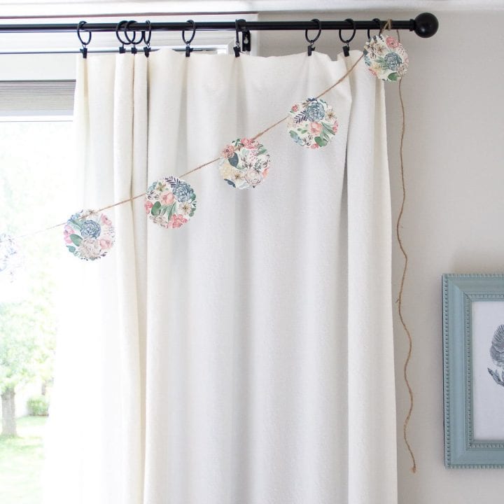 A DIY No-Sew Paper Garland hanging on a curtain rod.