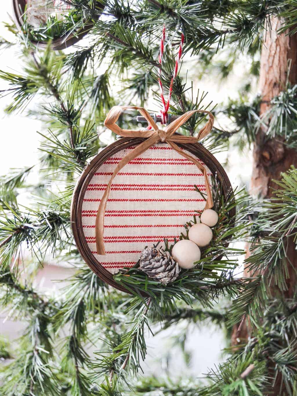 A wooden embroidery hoop decorated to become a Christmas tree ornament.
