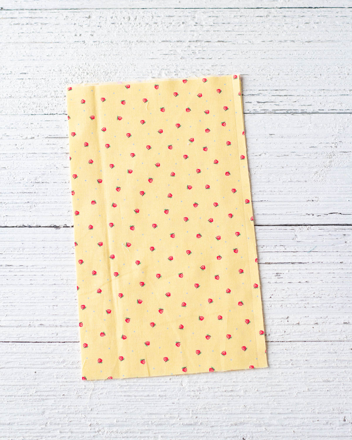 Yellow printed fabric on a wooden surface.