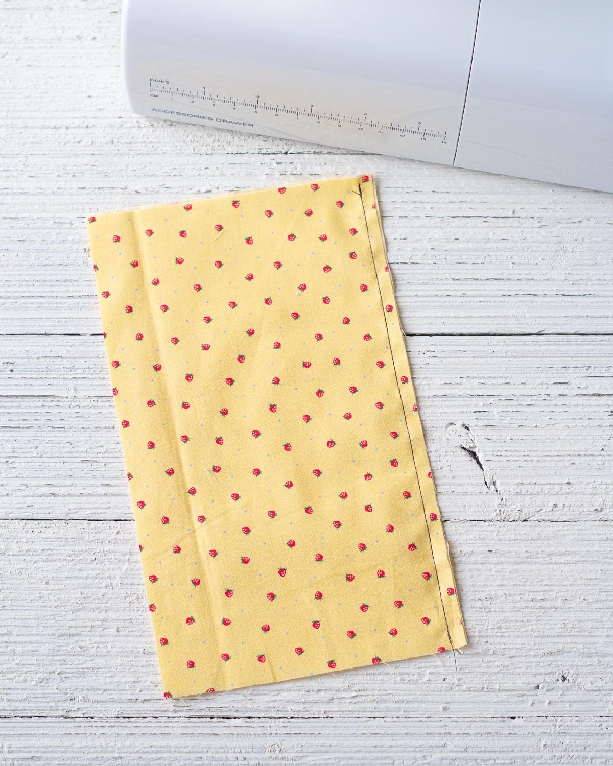 A seam sewn with contrasting thread on a rectangle of yellow fabric.