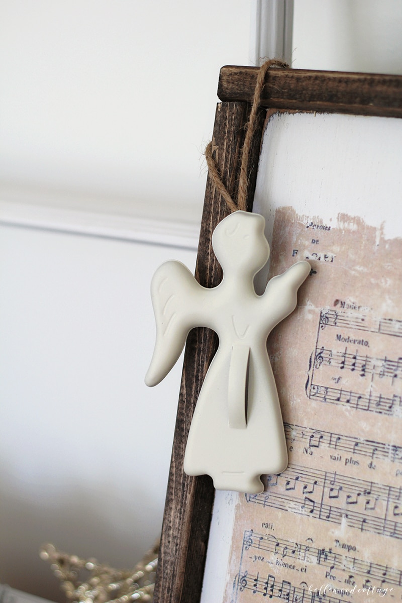 A cookie cutter ornament hanging on a Christmas print.