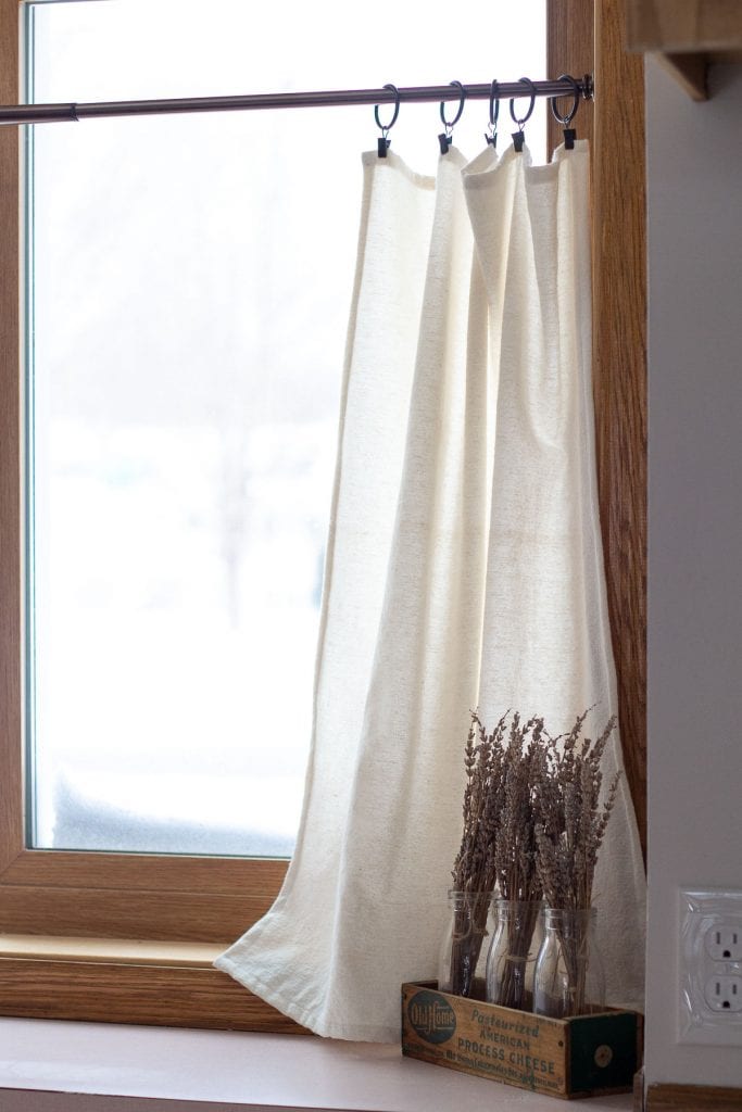 Drop cloth curtains in a kitchen window.