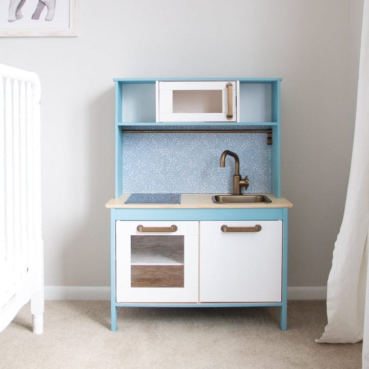 An IKEA play kitchen hack painted with blue chalk style paint.