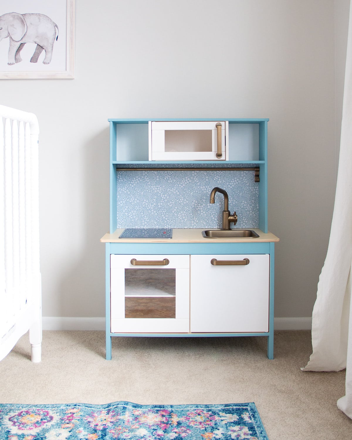 An IKEA play kitchen hack painted with blue chalk style paint.