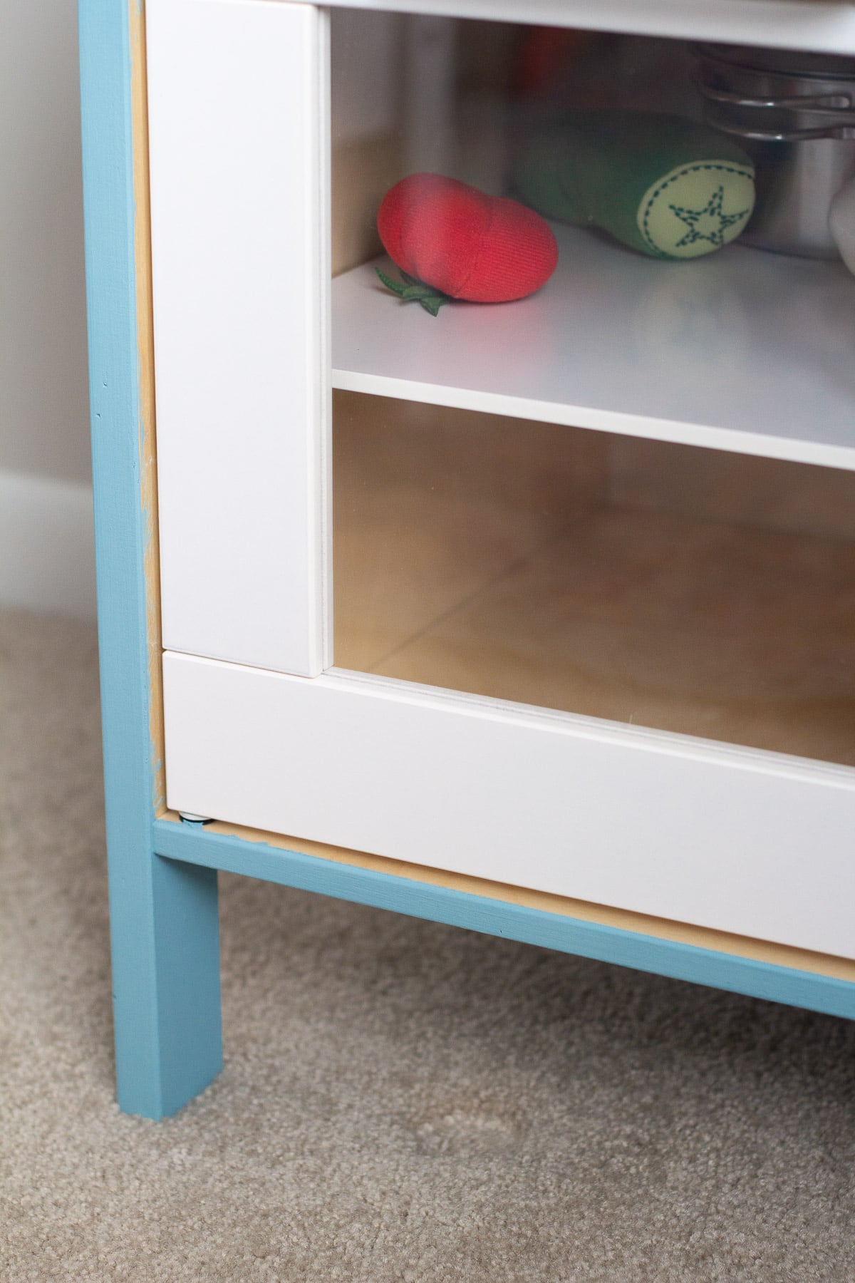 An IKEA play kitchen hack painted with blue chalk style paint.