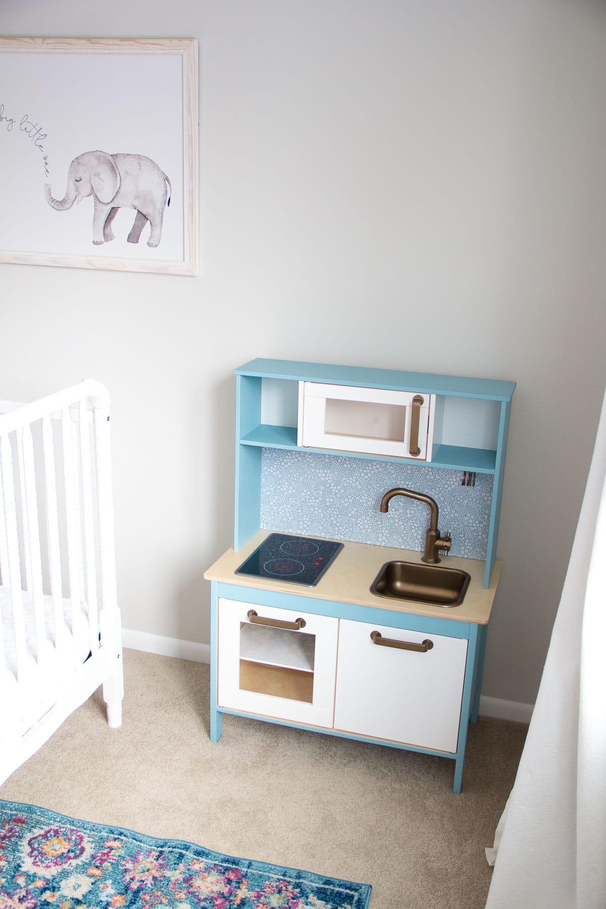 An IKEA play kitchen hack painted with blue chalk style paint.