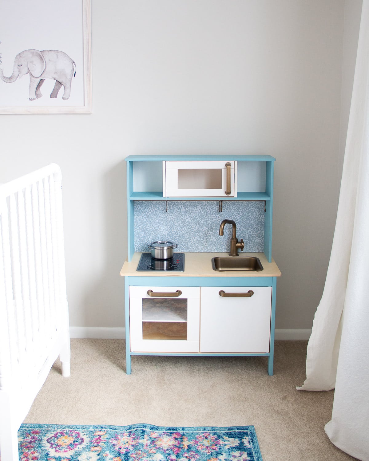 An IKEA play kitchen hack painted with blue chalk style paint.