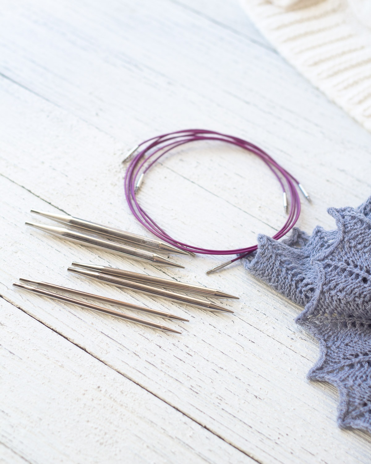 Gift idea for new knitters: Knit Picks Nickel Interchangeable Knitting Needle Set on a wooden surface.