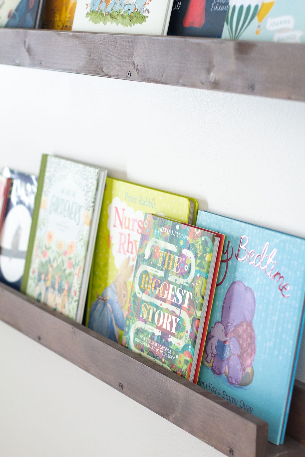 The Biggest Story and other children's books displayed on floating wall shelves.