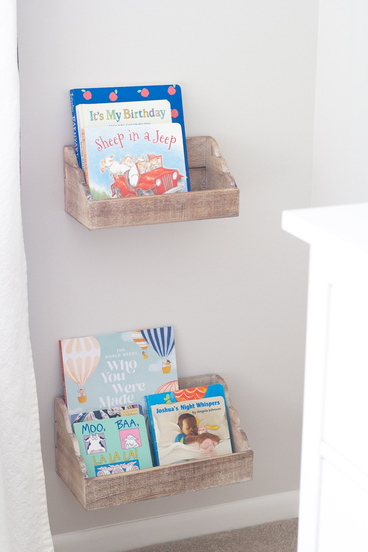 Kids' books in a nursery displayed in floating shelves.