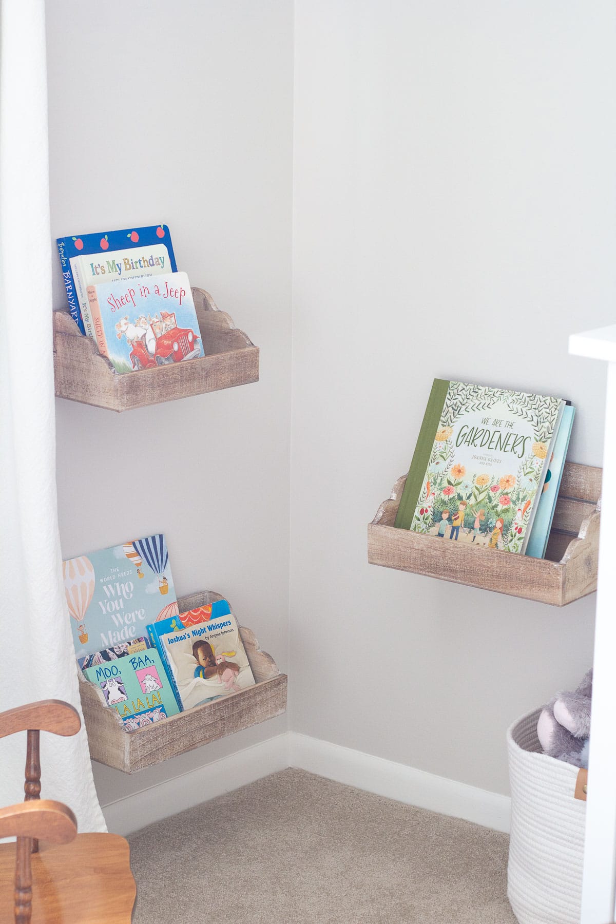 Kids' books in a nursery displayed in floating shelves from Hobby Lobby.