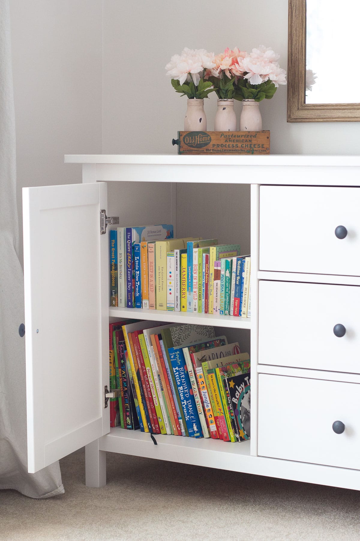 An open cupboard displaying children's picture books and board books.