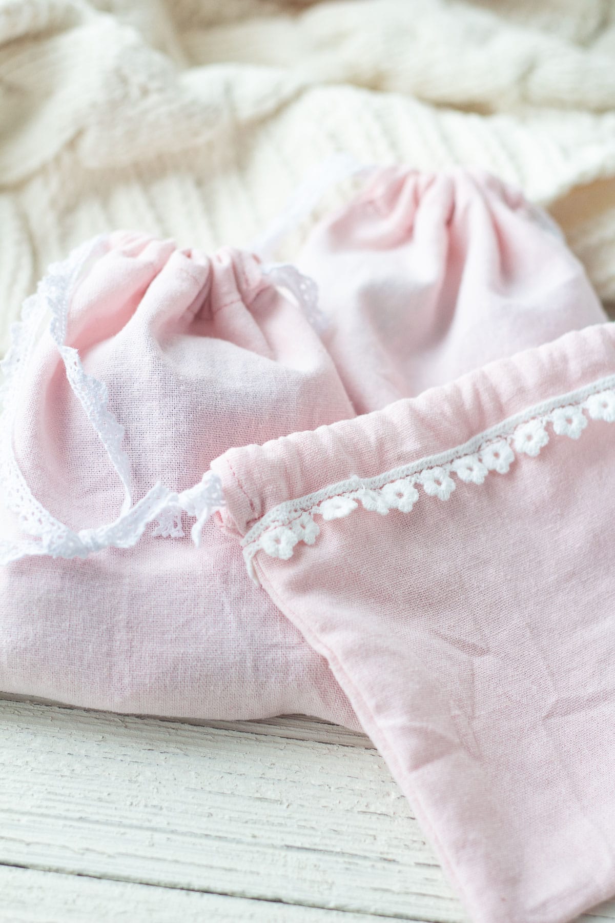 Pink linen drawstring bags with a lace edge.