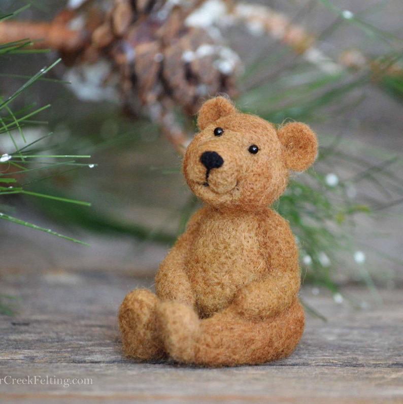 A needle felted teddy bear made from a kit.