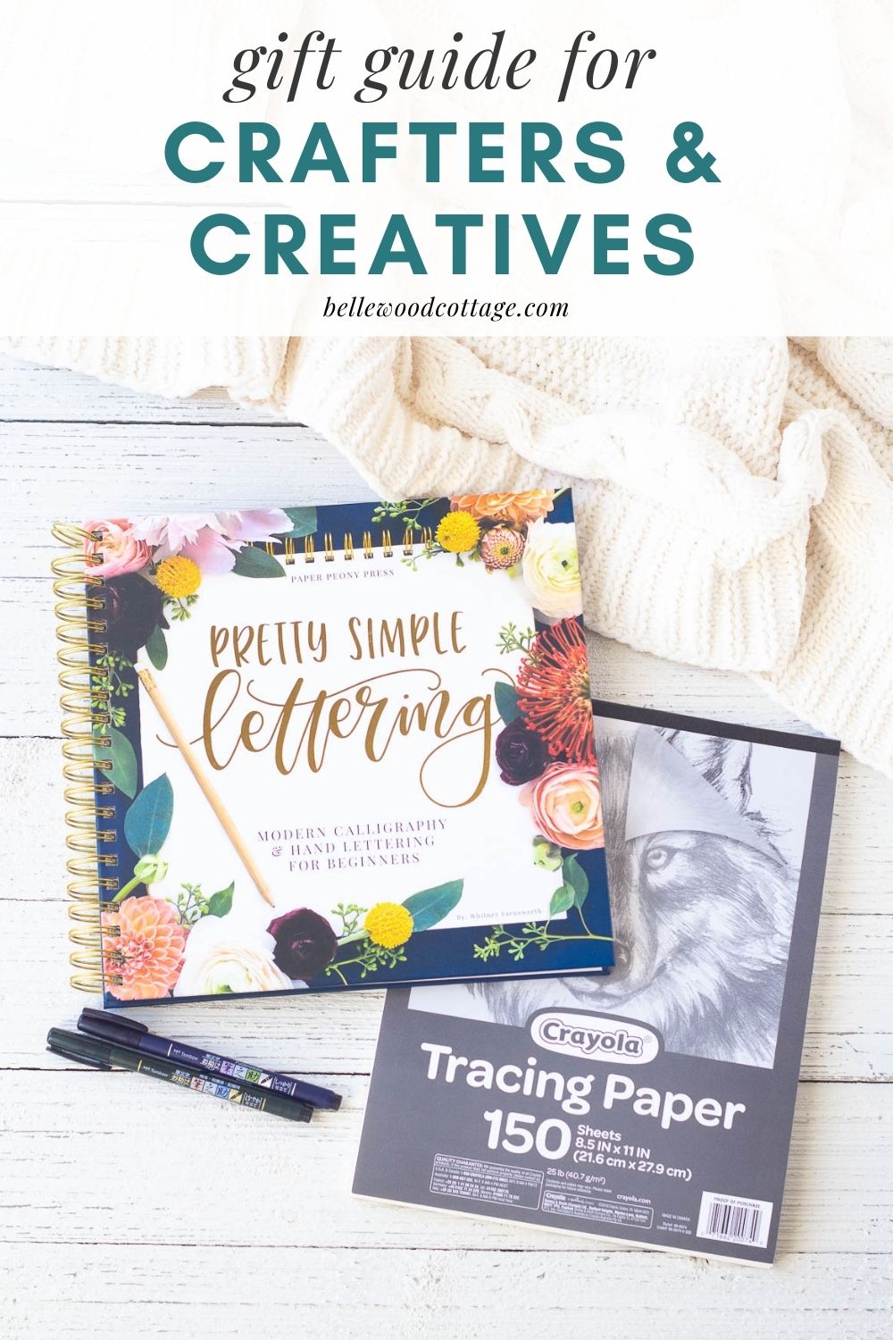 A hand-lettering instructional book alongside brush pens and tracing paper, with the words, "Gift Guide for Crafters and Creatives."