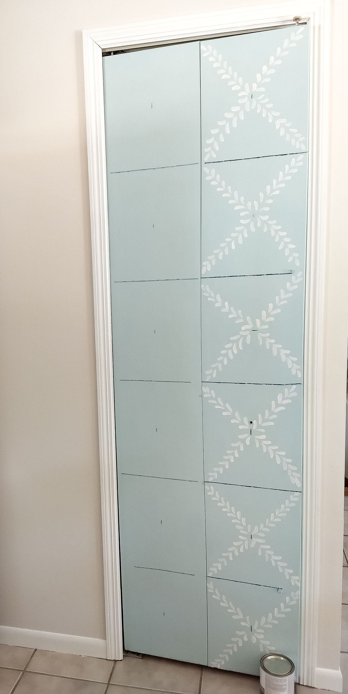 Using washi tape to mark out a design on a pantry door.