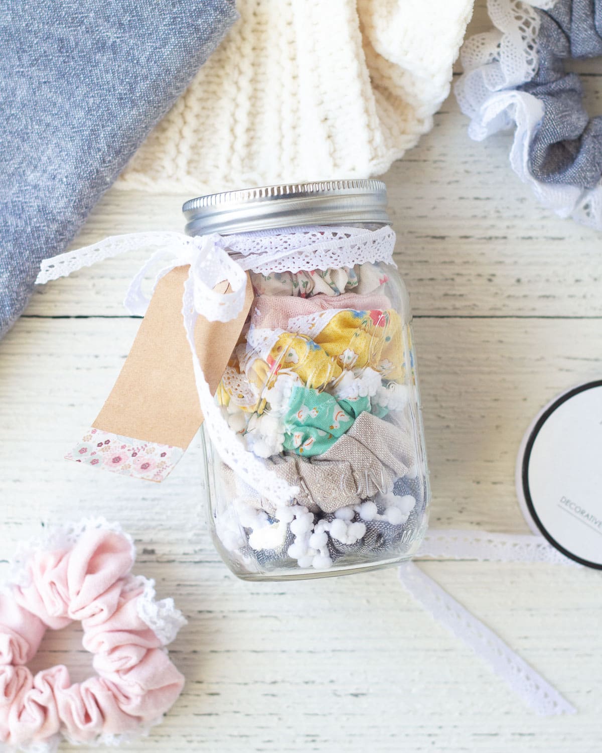 A mason jar filled with scrunchies on a wooden background.