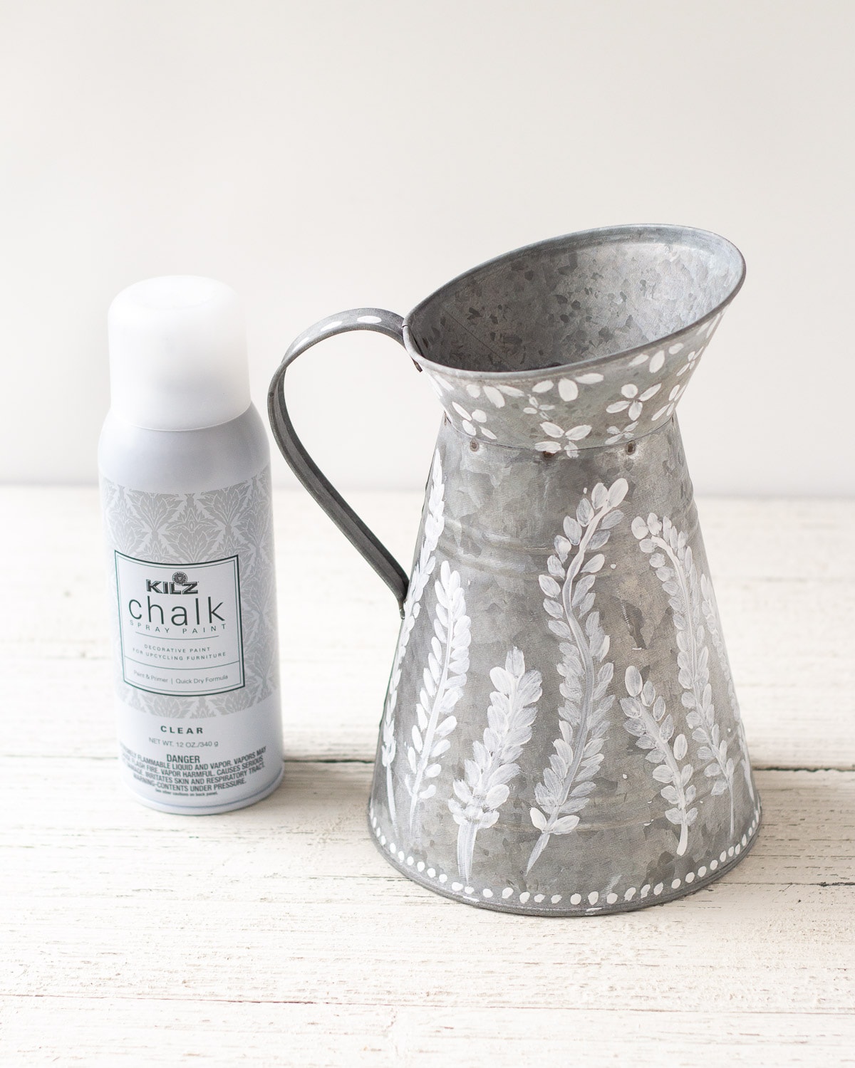 A can of clear matte spray paint and a painted farmhouse pitcher.