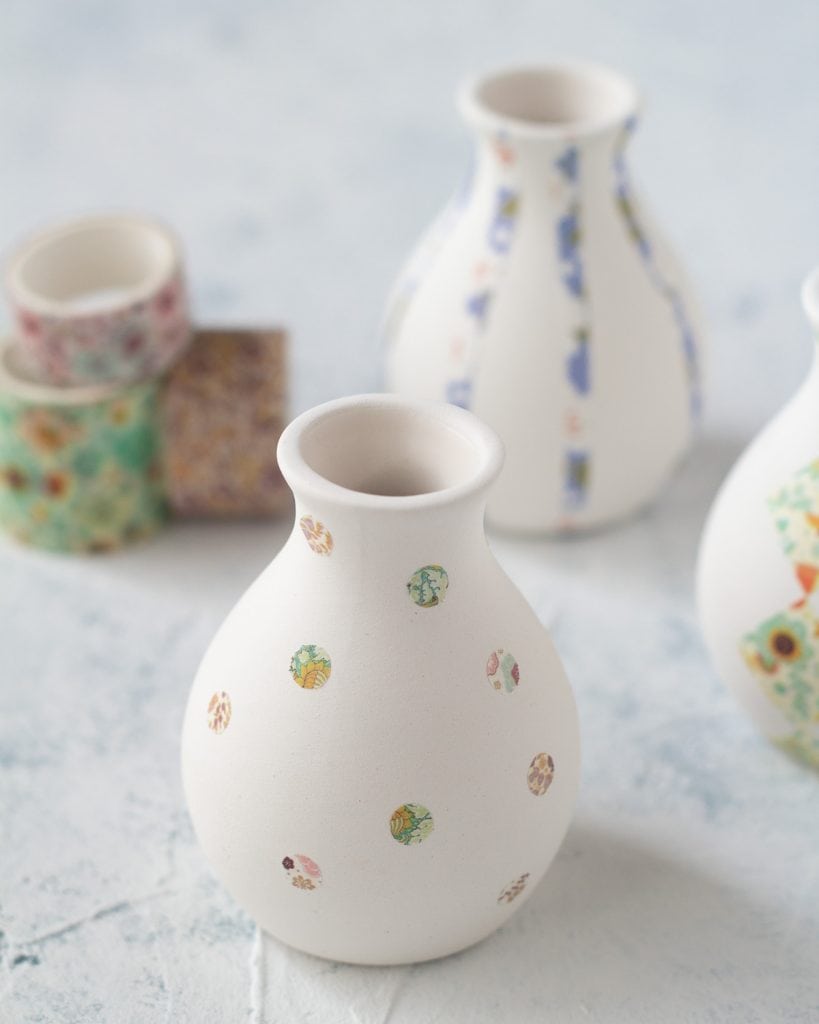 A bud vase decorated with washi tape polka-dots.