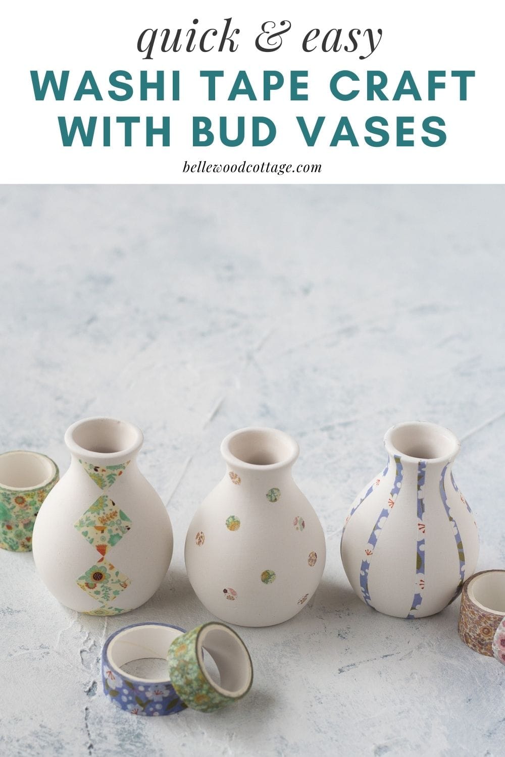Decorated vases and spools of washi tape on a rustic surface.