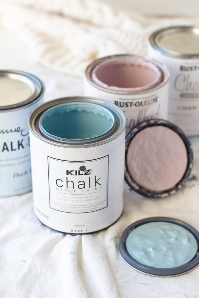 Open cans of blue and pink chalk paint.