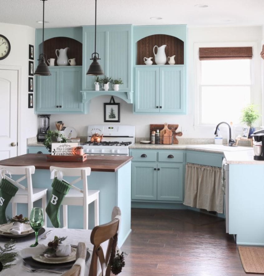 A cozy cottage kitchen with blue cabinets decorated for the holidays.