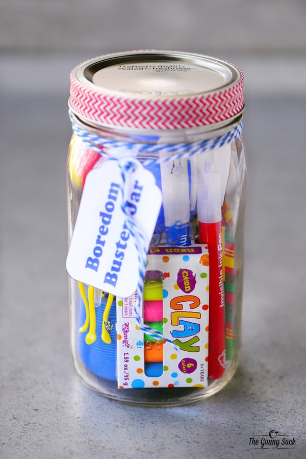 A "boredom buster" mason jar filled with gift ideas for kids.