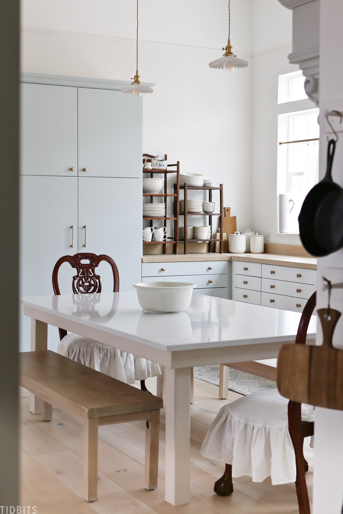 A European kitchen with subtle blue cabinetry and antique décor.