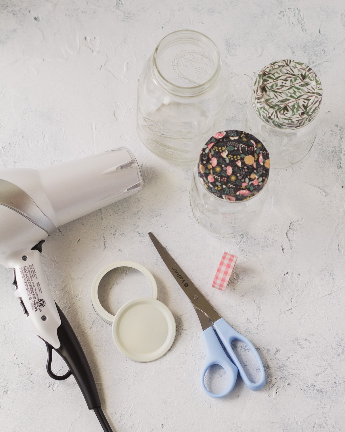 Hair dryer, mason jar lids, scissors, and washi tape mason jars.