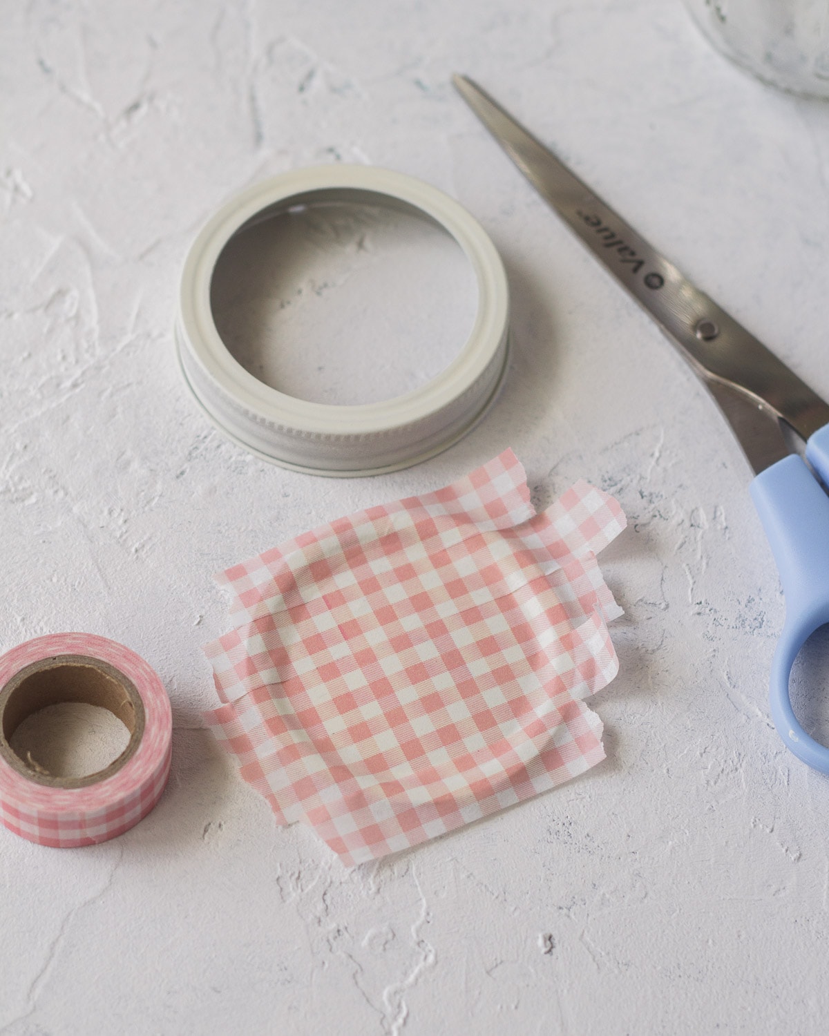 Glass jar lid covered with washi tape.