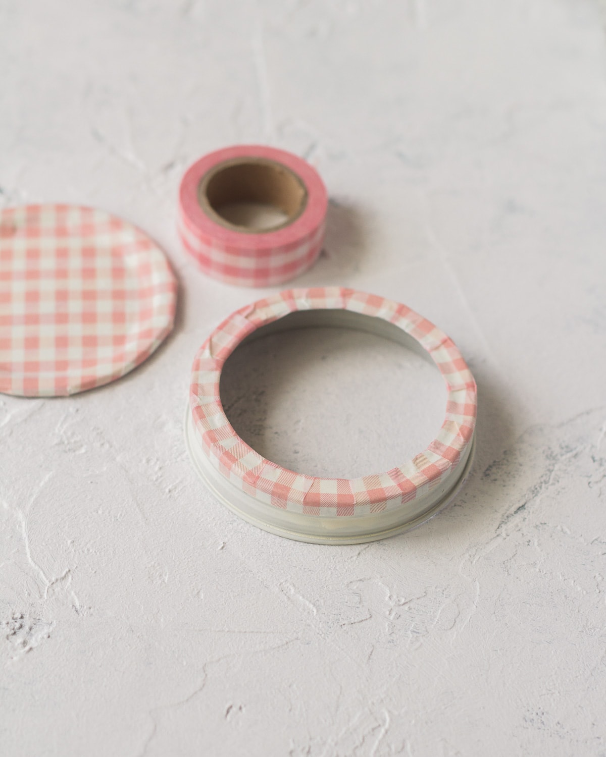 Glass jar lid covered in pink washi tape.