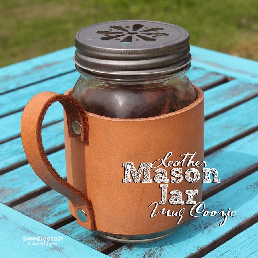 A mason jar decorated with a handmade leather mug coozie.