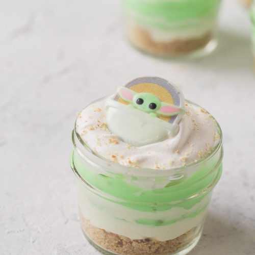 A mini pistachio dessert-in-a-jar topped with a Baby Yoda cupcake ring.